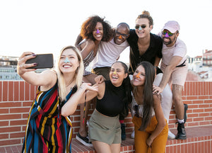 A group of friends taking a selfie to show off the colorful Nöz sunscreen on their noses